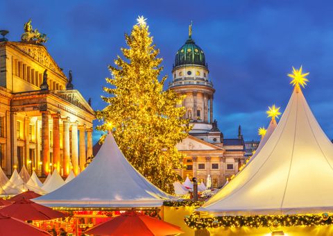 Beleuchteter Weihnachtsmarkt in Berlin mit Blick auf Französischen Dom und Konzerthaus